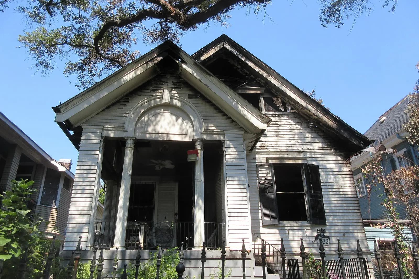 Exterior of a house after a fire, with smoke marks around the upper windows
