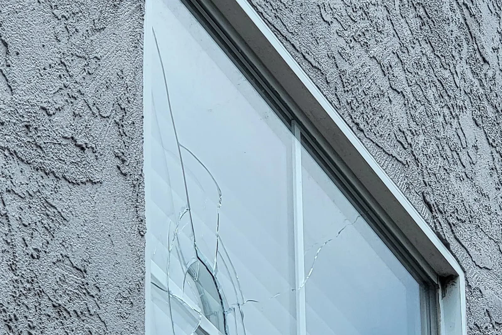 Broken window in a stucco wall